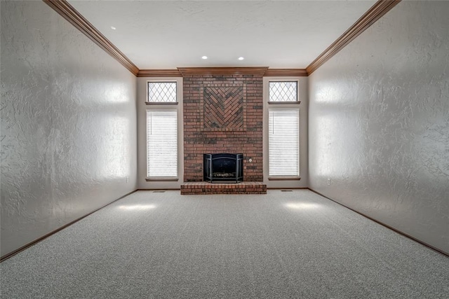 unfurnished living room with crown molding, a fireplace, and a wealth of natural light