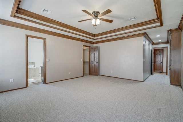 spare room featuring a tray ceiling, ceiling fan, light carpet, and ornamental molding