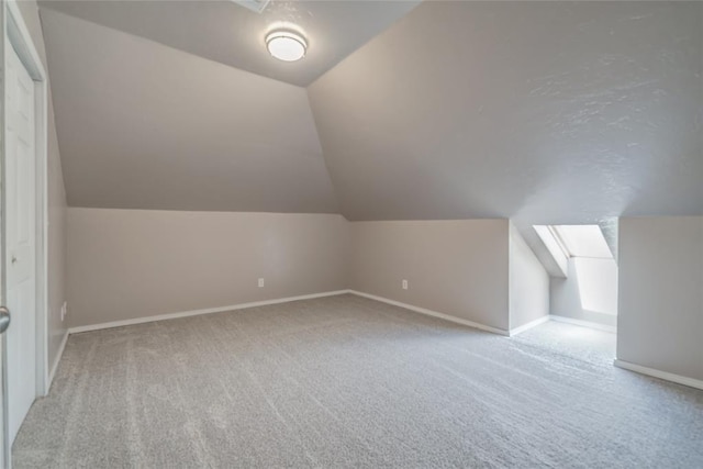 bonus room featuring light colored carpet and vaulted ceiling