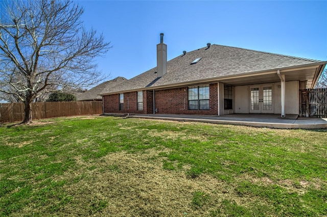 back of property featuring french doors, a yard, and a patio