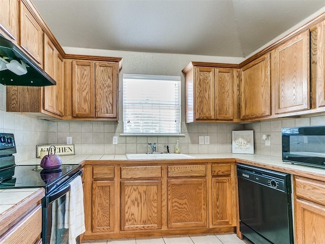 kitchen featuring backsplash, exhaust hood, black appliances, sink, and light tile patterned flooring