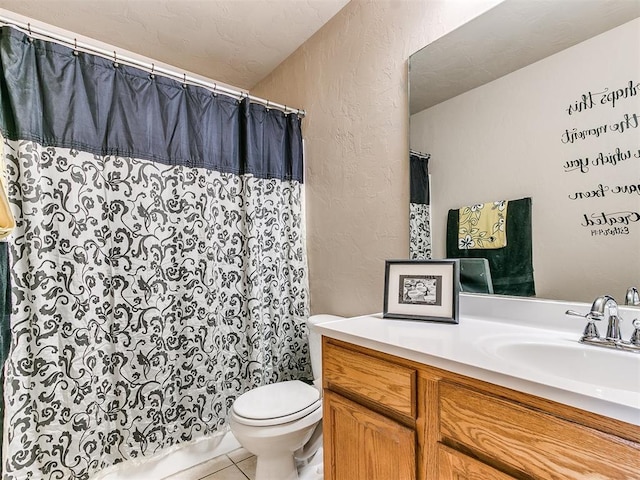 bathroom with toilet, vanity, and tile patterned floors