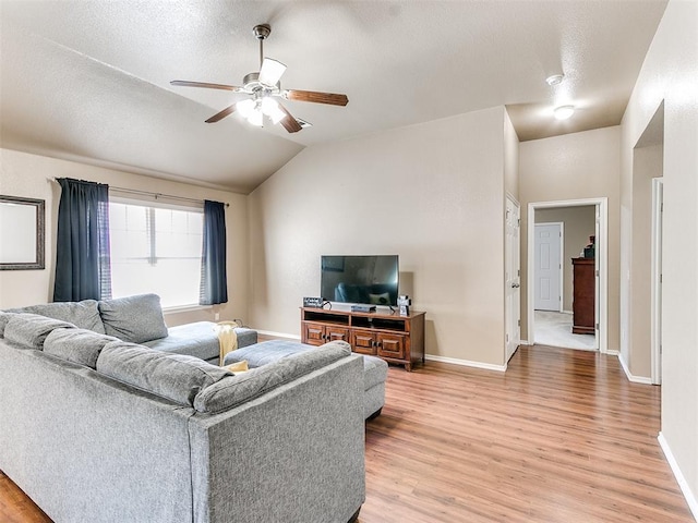 living room featuring a textured ceiling, hardwood / wood-style flooring, ceiling fan, and lofted ceiling