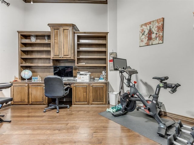 office area with light wood-type flooring and built in desk