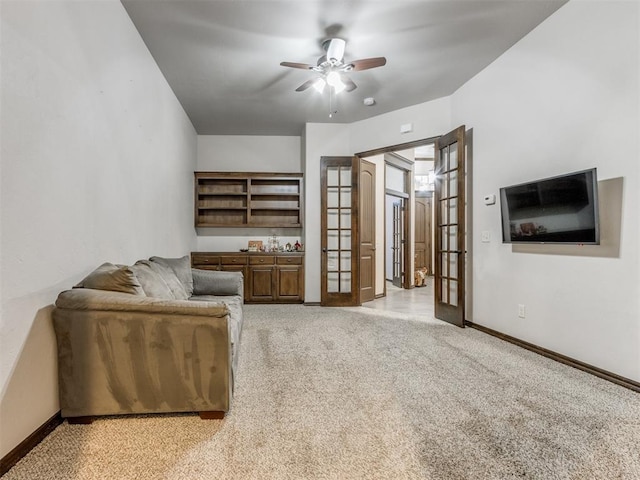 living room featuring ceiling fan, french doors, and light colored carpet