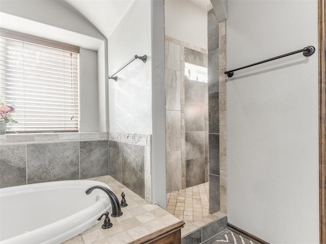 bathroom with shower with separate bathtub and vaulted ceiling