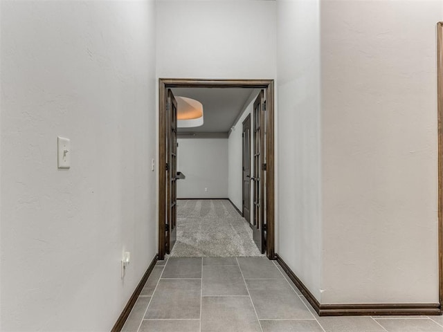 hall with tile patterned floors