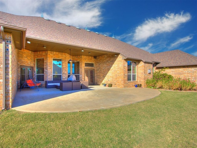 rear view of property with outdoor lounge area, a yard, and a patio