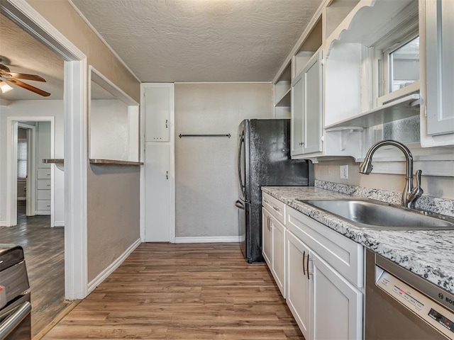 kitchen with dishwasher, white cabinets, sink, light wood-type flooring, and a textured ceiling