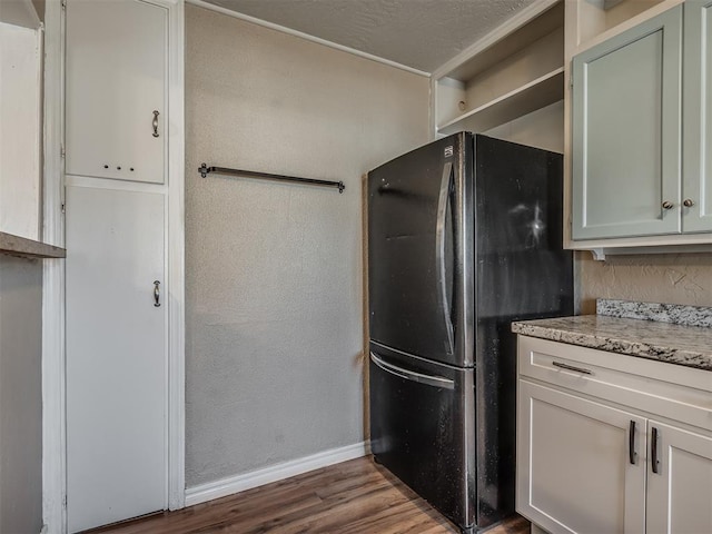 kitchen featuring black refrigerator and dark wood-type flooring