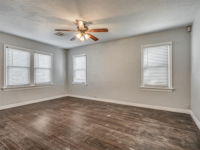 spare room with dark hardwood / wood-style floors, ceiling fan, and a textured ceiling