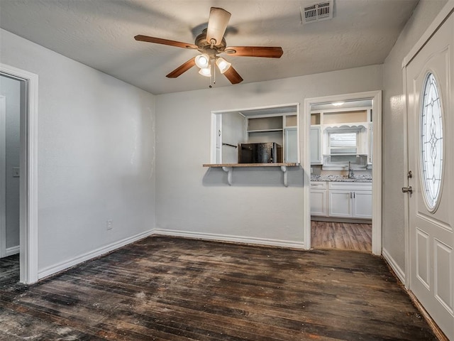 foyer with ceiling fan, a healthy amount of sunlight, and dark hardwood / wood-style flooring