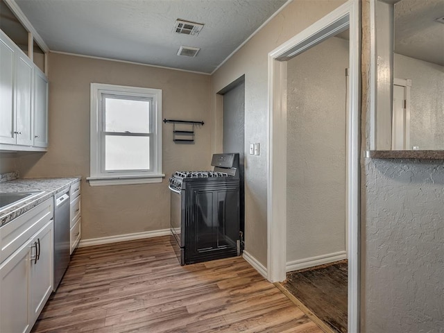 kitchen with stainless steel dishwasher, black range, light hardwood / wood-style floors, and white cabinetry