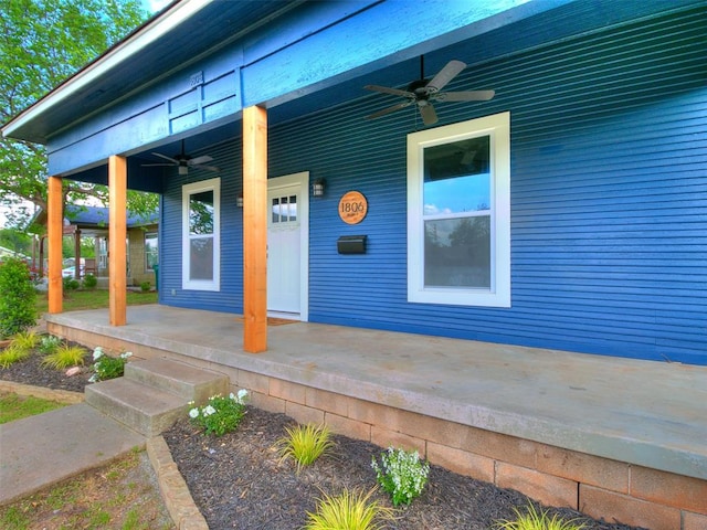 view of exterior entry featuring covered porch and ceiling fan