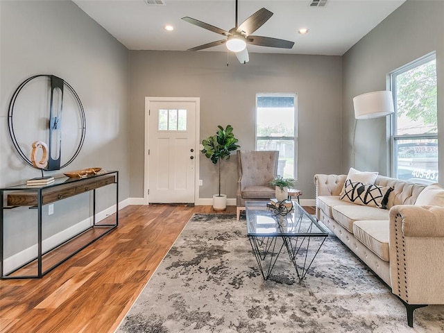 living room with a wealth of natural light, ceiling fan, and light hardwood / wood-style floors