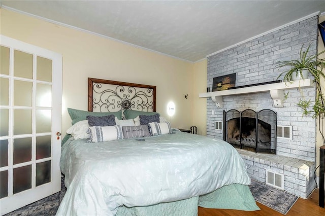 bedroom with a fireplace, hardwood / wood-style flooring, and ornamental molding