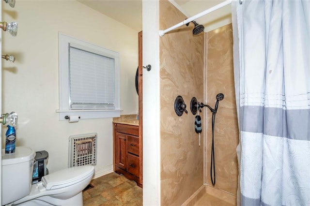 bathroom with heating unit, curtained shower, vanity, and toilet