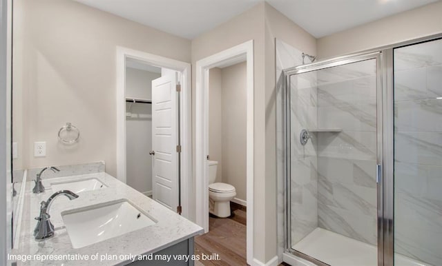 541 Park Pl, Newcastle, OK 73065 - bathroom featuring a shower stall, double vanity, toilet, wood finished floors, and a spacious closet