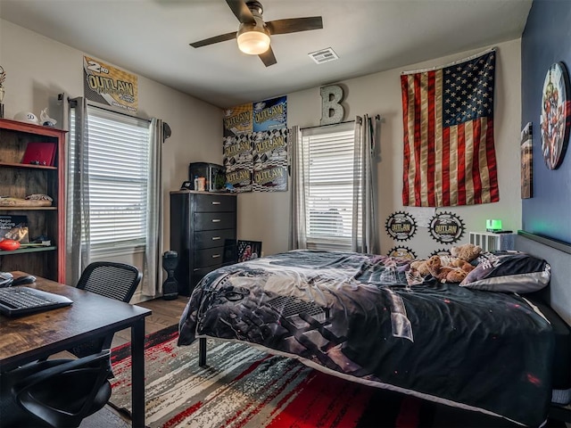 bedroom featuring multiple windows, ceiling fan, and wood-type flooring