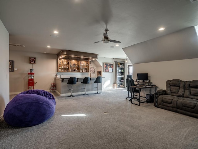 carpeted living room with ceiling fan, bar, and vaulted ceiling