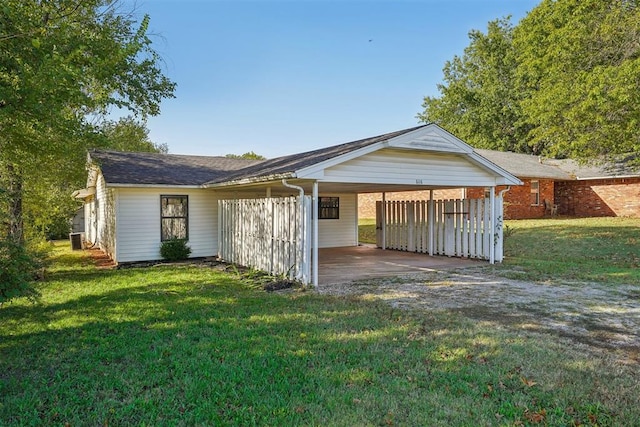 back of house with a lawn and a carport