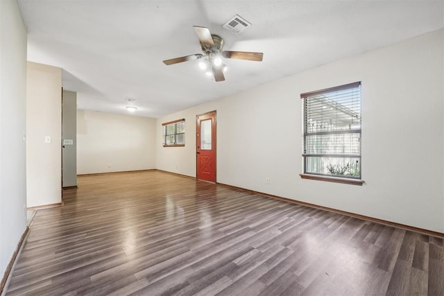 empty room with ceiling fan and dark wood-type flooring