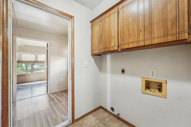 clothes washing area featuring cabinets, hookup for a washing machine, hookup for an electric dryer, light hardwood / wood-style flooring, and hookup for a gas dryer