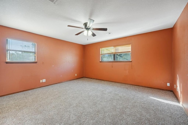 unfurnished room featuring ceiling fan, carpet, and a textured ceiling