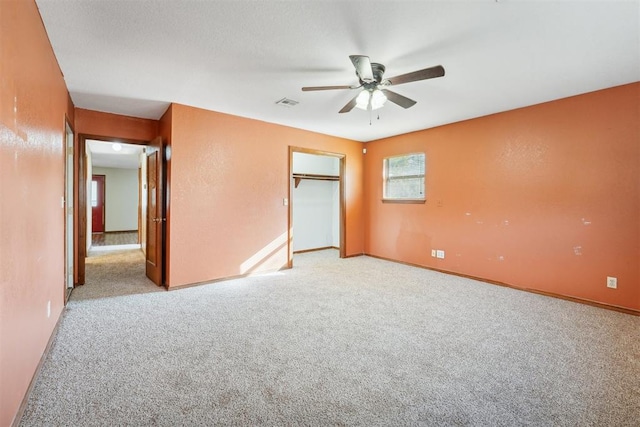 unfurnished bedroom with light carpet, a closet, and ceiling fan