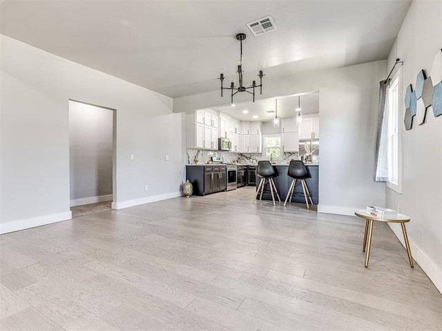 interior space with a chandelier, light wood-type flooring, and a wealth of natural light