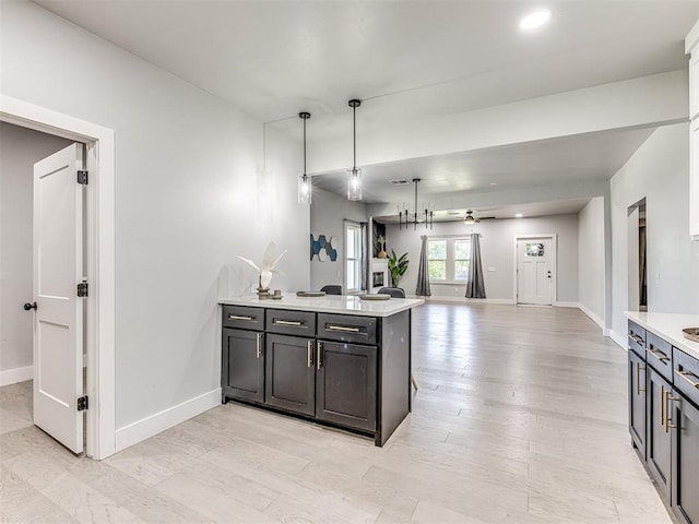 kitchen with kitchen peninsula, pendant lighting, light hardwood / wood-style flooring, and ceiling fan