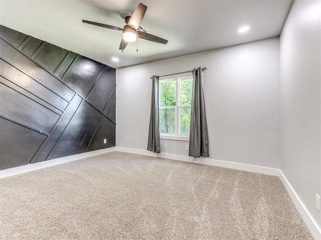 spare room with ceiling fan and carpet