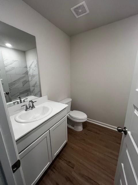 bathroom with vanity, wood-type flooring, and toilet