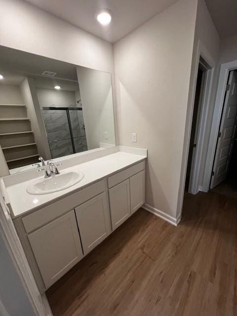 bathroom featuring vanity, a shower with door, and wood-type flooring