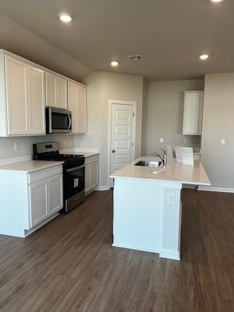 kitchen featuring sink, white cabinetry, stainless steel appliances, a center island with sink, and dark hardwood / wood-style flooring