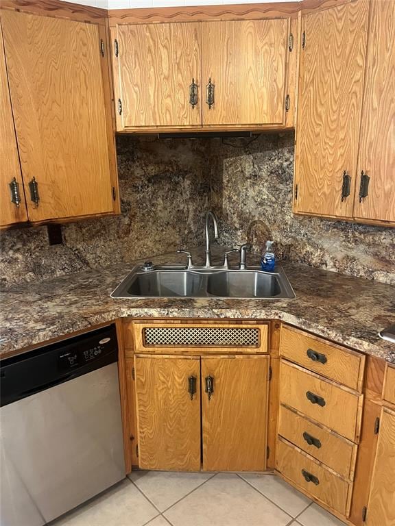 kitchen featuring decorative backsplash, sink, light tile patterned flooring, and stainless steel dishwasher