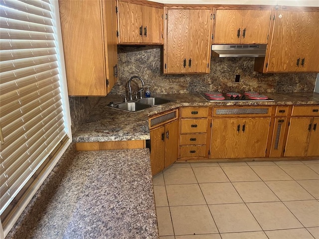 kitchen with black electric stovetop, decorative backsplash, light tile patterned floors, and sink