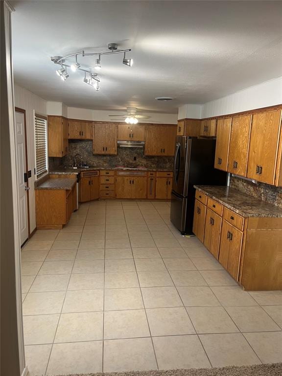 kitchen featuring stainless steel fridge, tasteful backsplash, ceiling fan, sink, and light tile patterned floors