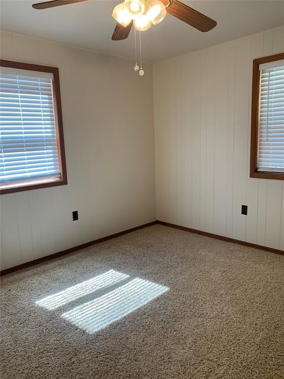 carpeted spare room with ceiling fan