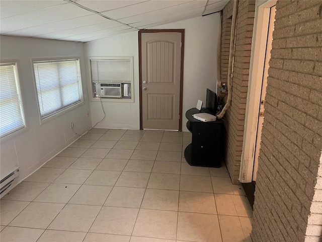 hallway with cooling unit, light tile patterned flooring, baseboard heating, and vaulted ceiling