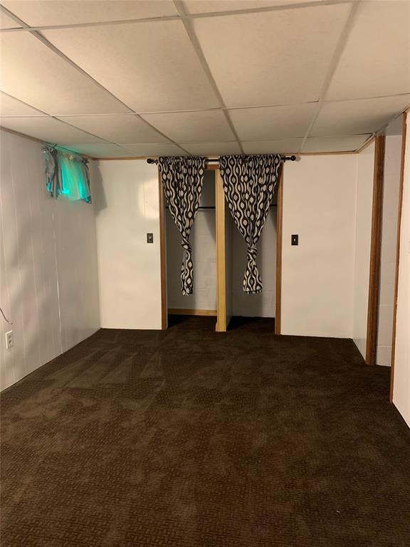 basement featuring carpet and a paneled ceiling