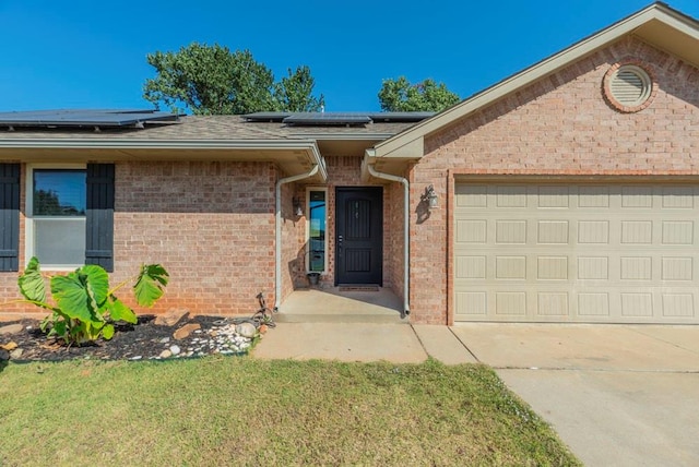 ranch-style home with solar panels and a garage