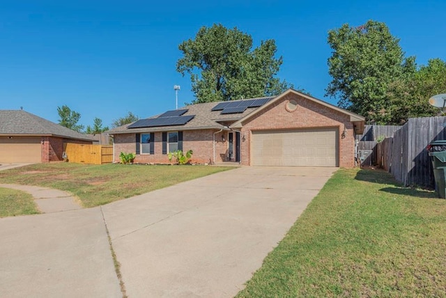 single story home featuring a garage, a front yard, and solar panels