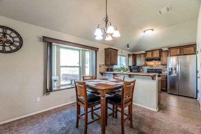 dining area featuring tile patterned flooring, vaulted ceiling, and a notable chandelier