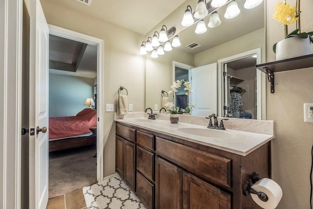 bathroom featuring tile patterned flooring, vanity, and a notable chandelier