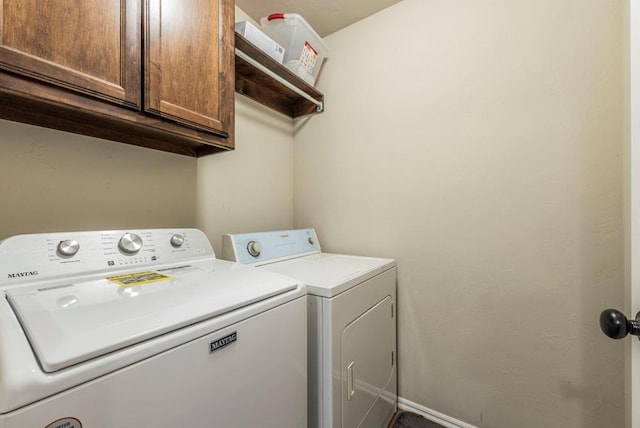 laundry room with washing machine and clothes dryer and cabinets