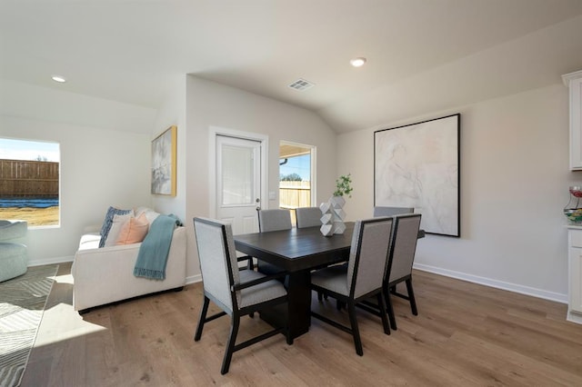 dining space featuring lofted ceiling, recessed lighting, visible vents, light wood-style floors, and baseboards