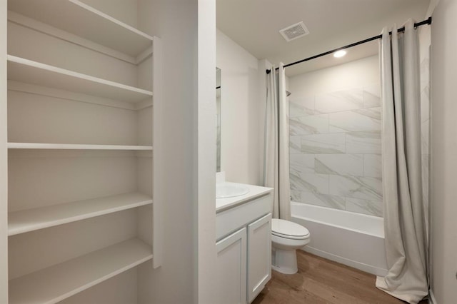 bathroom featuring shower / tub combo, visible vents, toilet, wood finished floors, and vanity