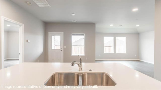 kitchen featuring a healthy amount of sunlight, light countertops, a sink, and recessed lighting