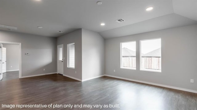 empty room featuring dark wood-style floors, lofted ceiling, a healthy amount of sunlight, and visible vents